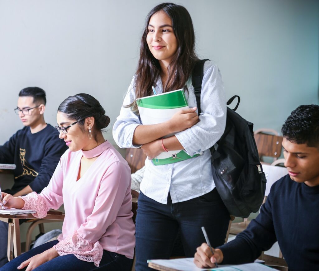 woman carrying white and green textbook